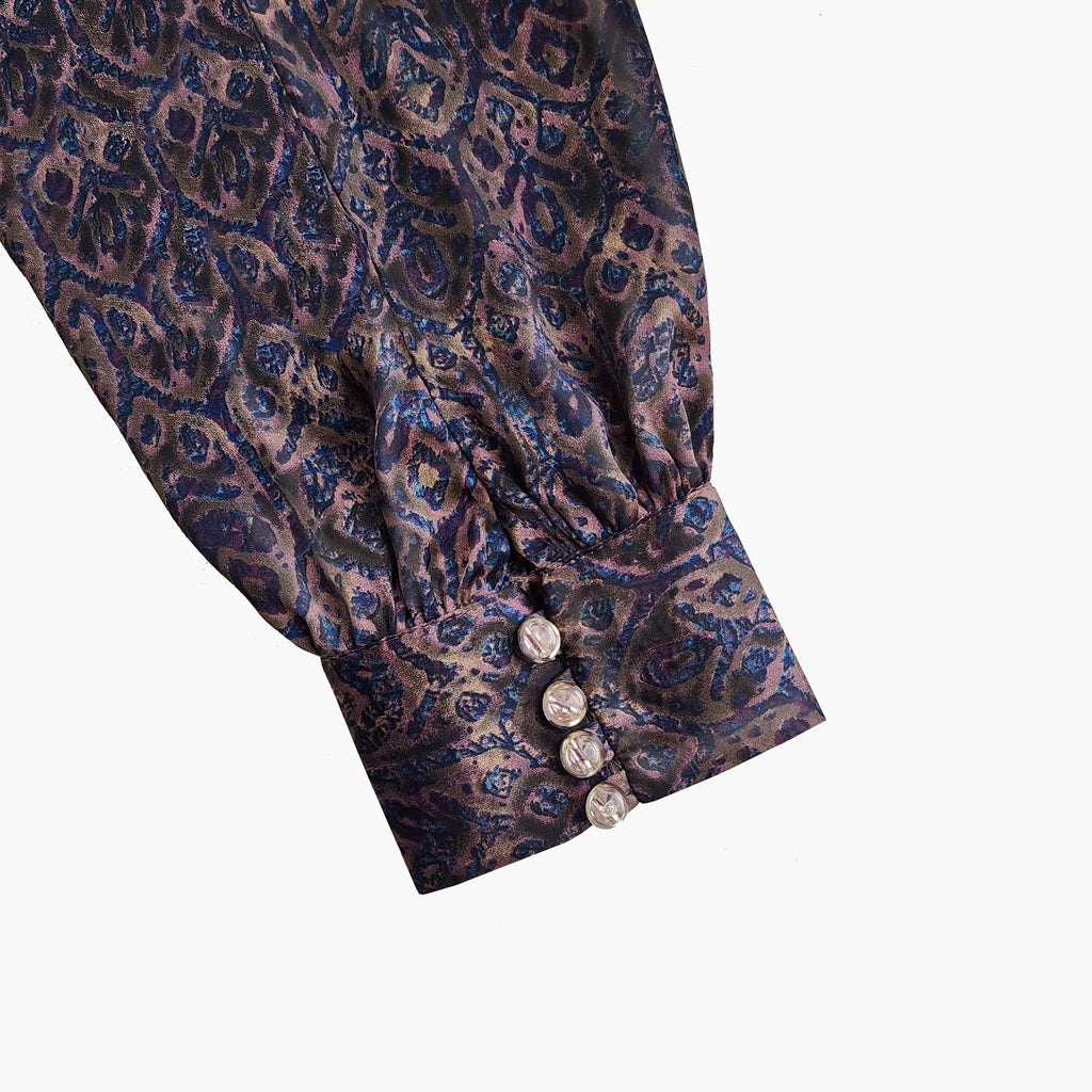 Close-up of quarter bishop sleeve with button & hook accents. Luxury lifestyle Dubai Marina.