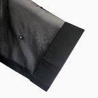 Close-up of hand mirror embellishments on a sheer mesh women's top